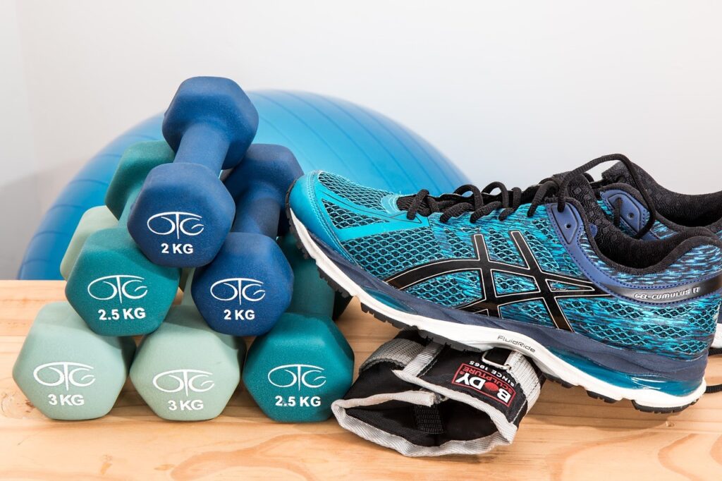 Dumbbells, running shoes, and fitness gear symbolizing exercise and resistance training — lifestyle foundations that creatine supplements help amplify for strength and health.