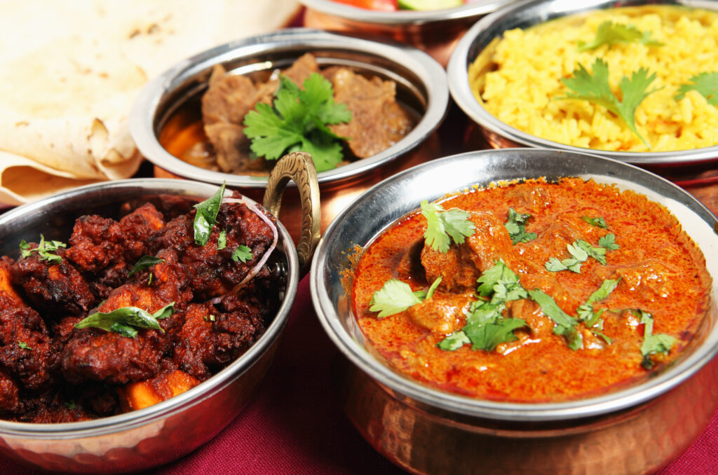 Spicy Indian dishes served in metal bowls — spicy foods can sometimes be a trigger for hot flushes. 