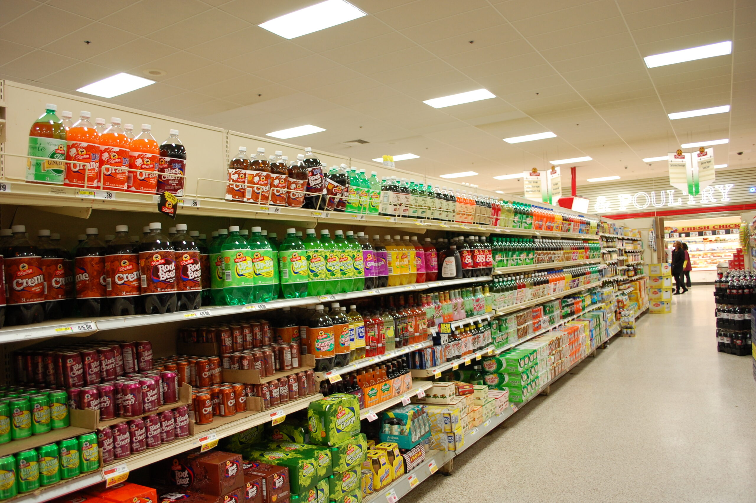 Supermarket aisle filled with sugary and artificially sweetened drinks, illustrating how common ultra-processed foods are in everyday diets.