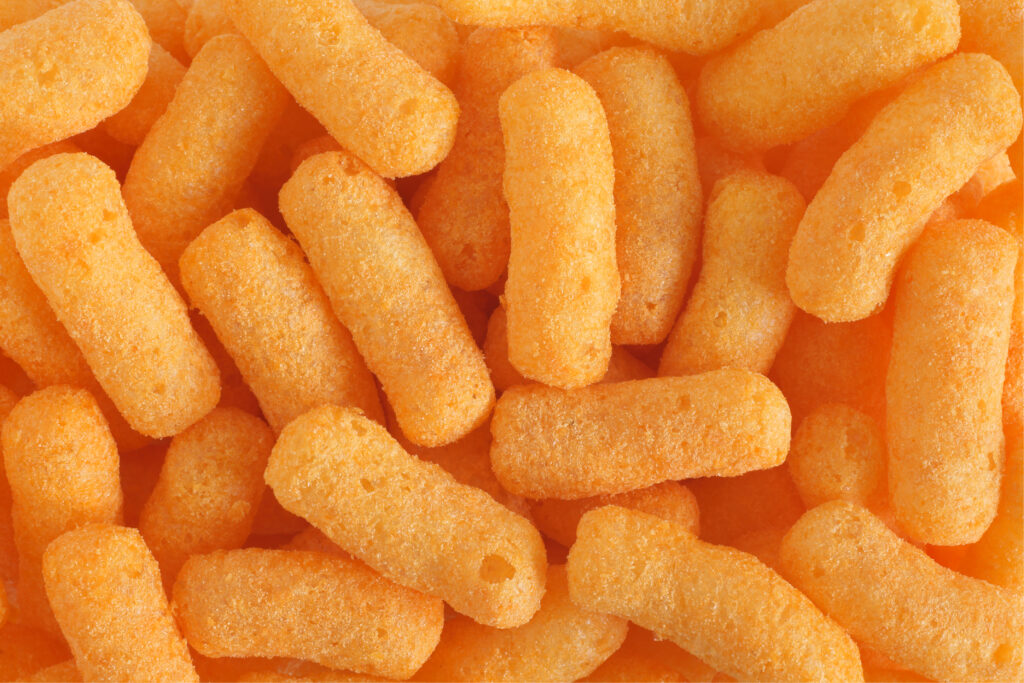 Cheese puffs showing how soft, melt-in-the-mouth ultra-processed foods are easy to overeat because they require little chewing.