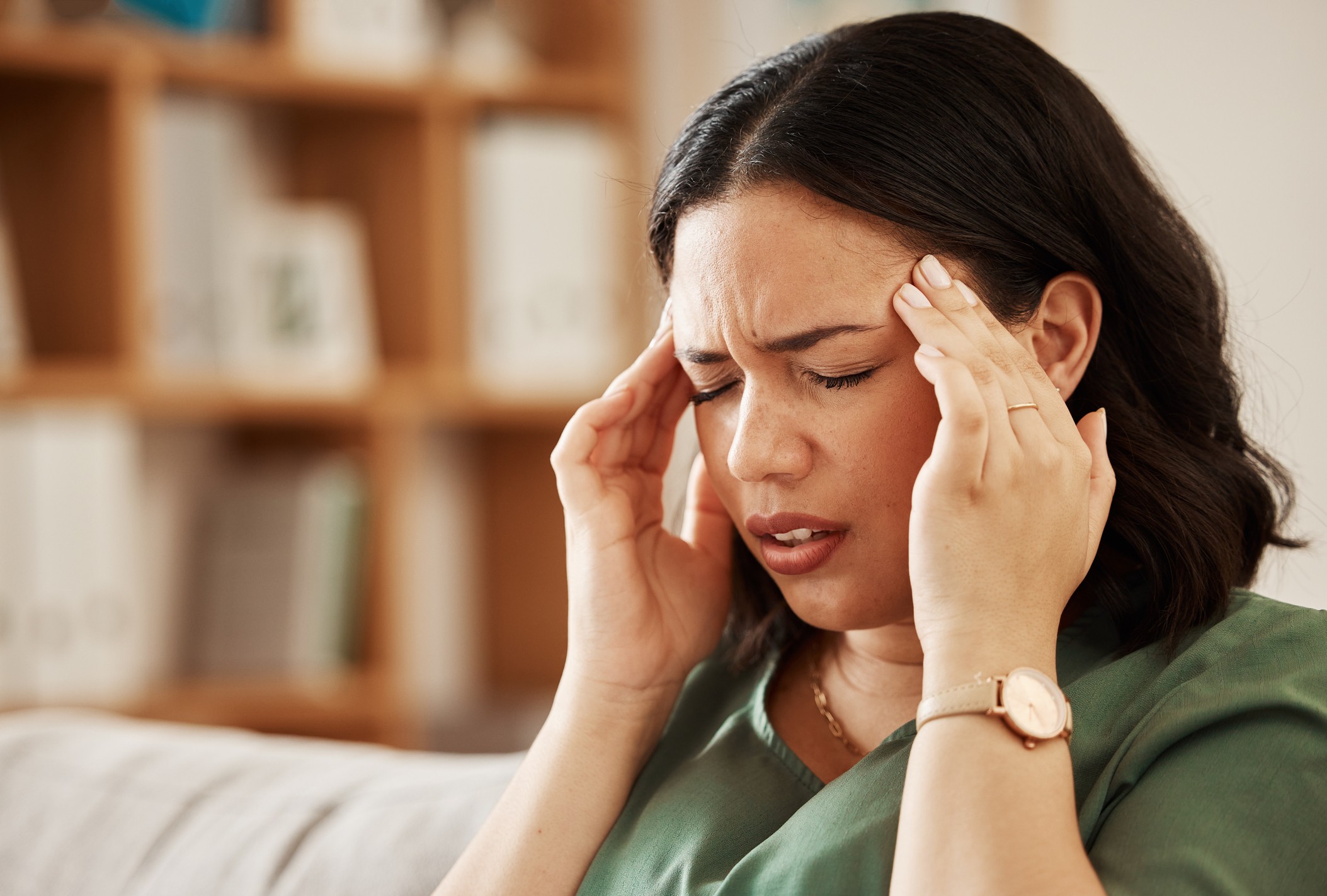 Woman holding her head looking overwhelmed, representing brain fog in menopause and difficulty concentrating