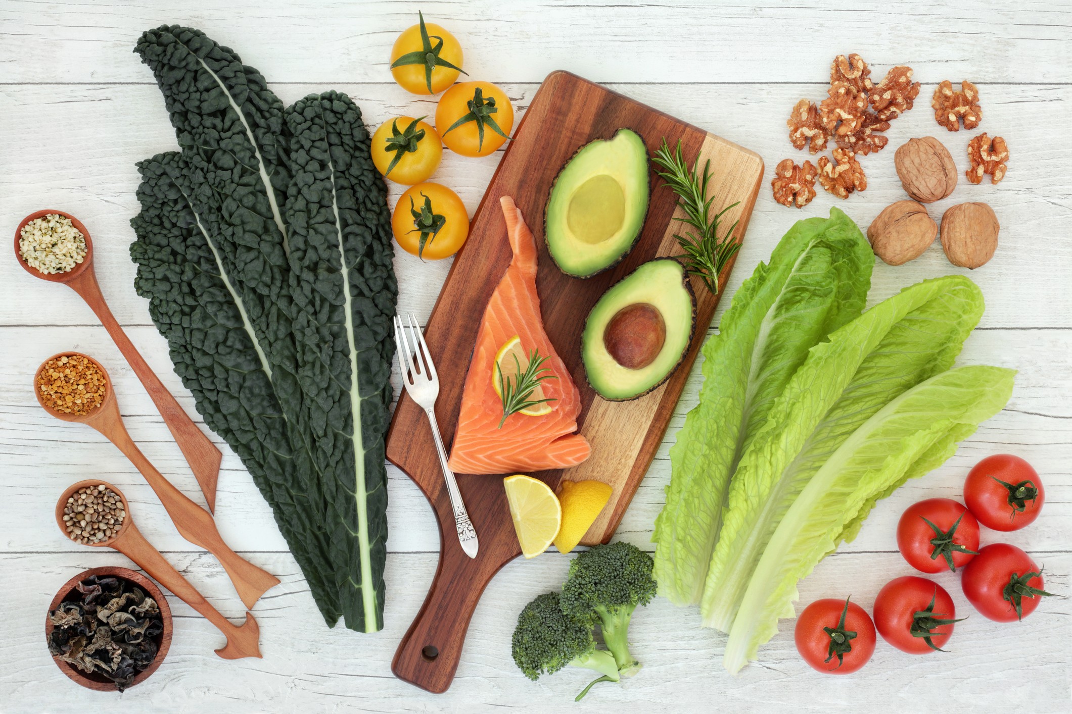 Mediterranean diet foods including salmon, avocado, leafy greens, nuts and vegetables that support brain health in menopause