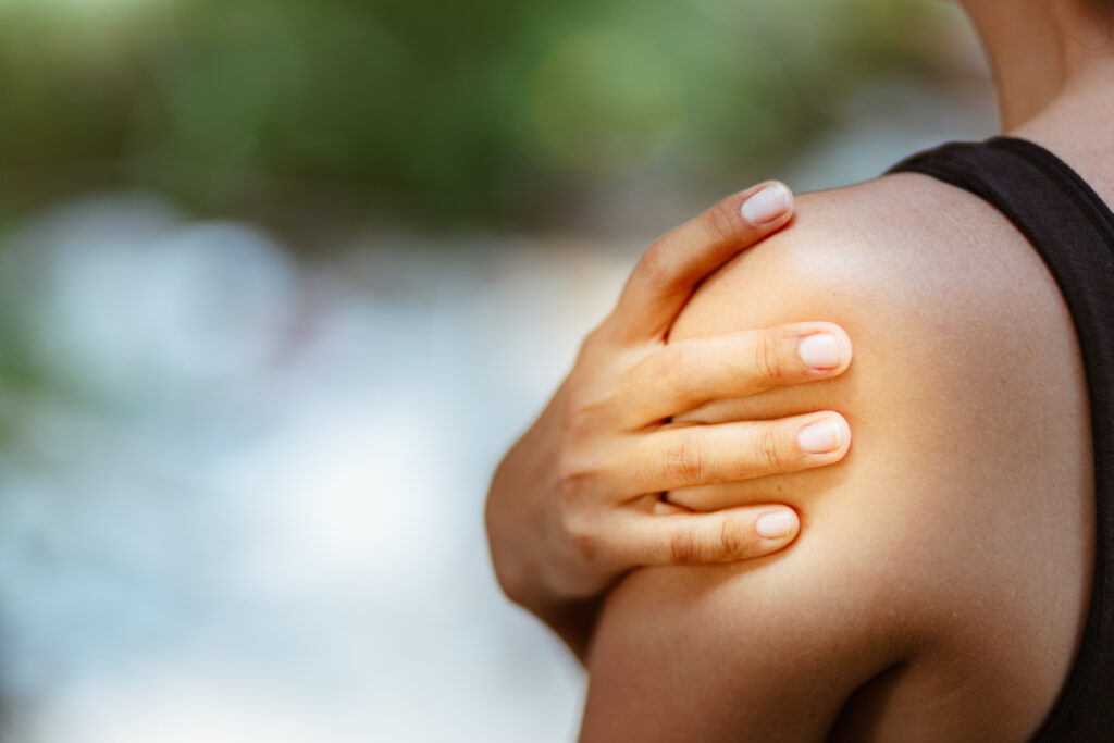 Woman holding a painful shoulder, a common area affected by menopause-related joint pain and stiffness