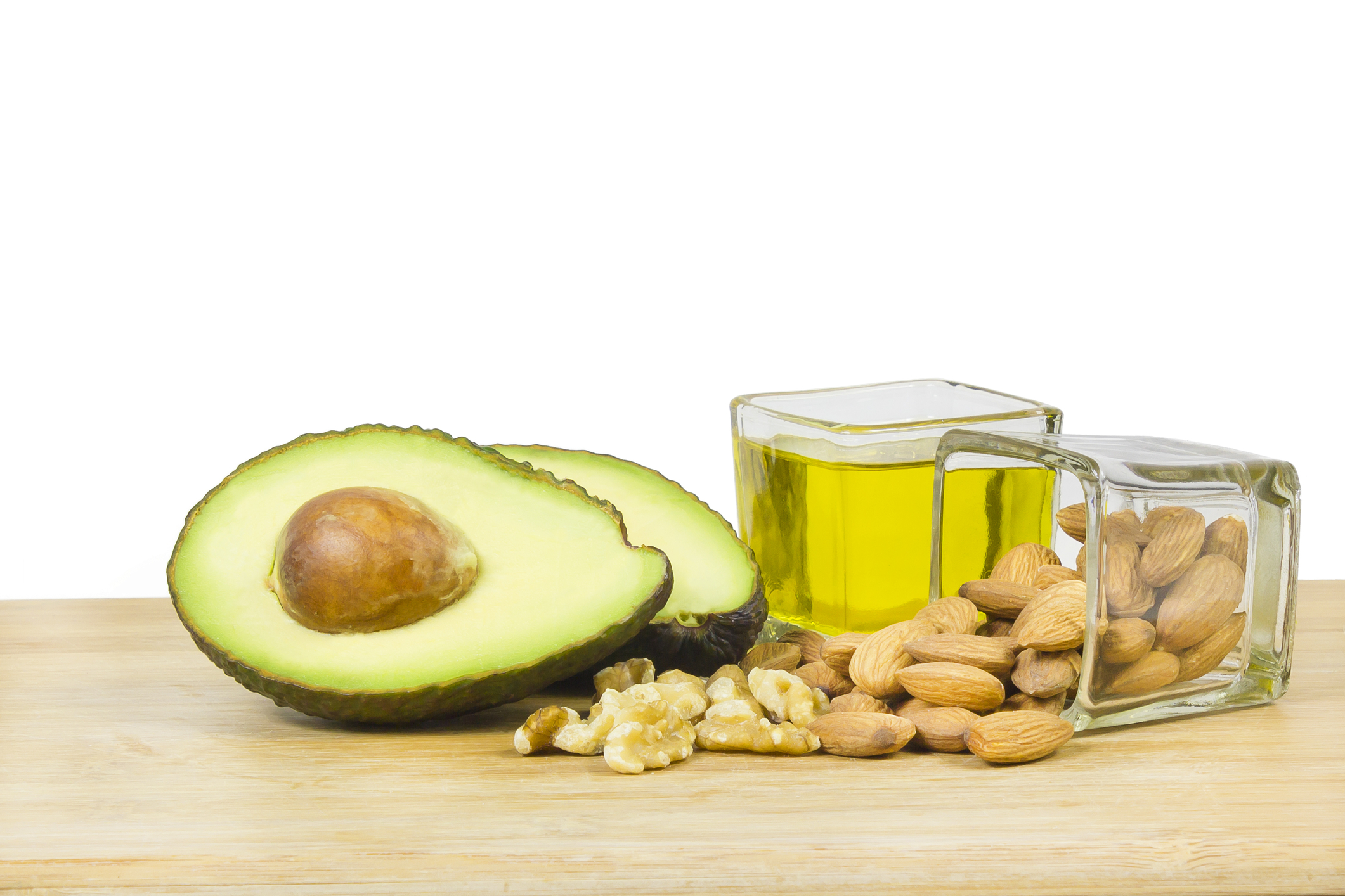 Avocado, olive oil, almonds and walnuts, illustrating sources of healthy unsaturated fats that support heart health and help create satisfying meals during and after menopause.